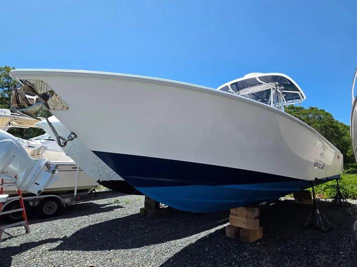 White Cap Yacht Photos Pics 2016 Contender 32 ST boat on blocks, blue and white hull, sunny day.