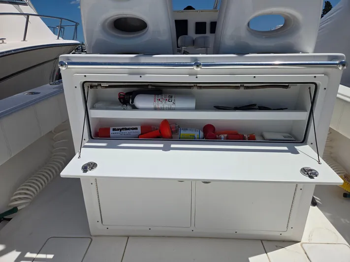 White Cap Yacht Photos Pics 2016 Contender 32 ST boat storage compartment with safety equipment and fire extinguisher.