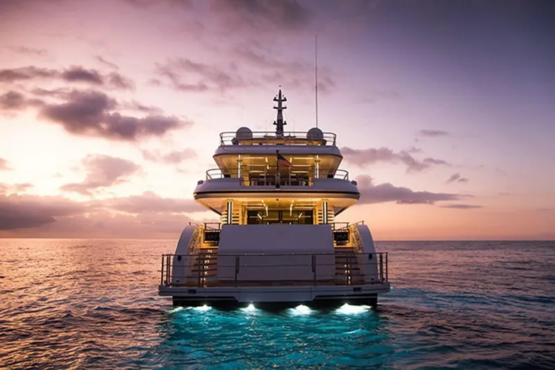 Checked Out Yacht Photos Pics Majesty 140 yacht at sunset, 2020 model, illuminated on calm ocean waters.