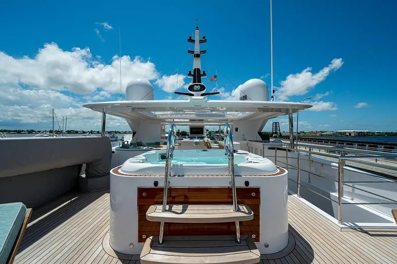Checked Out Yacht Photos Pics Luxury Majesty 140 yacht deck with jacuzzi, 2020 model, under clear blue sky.