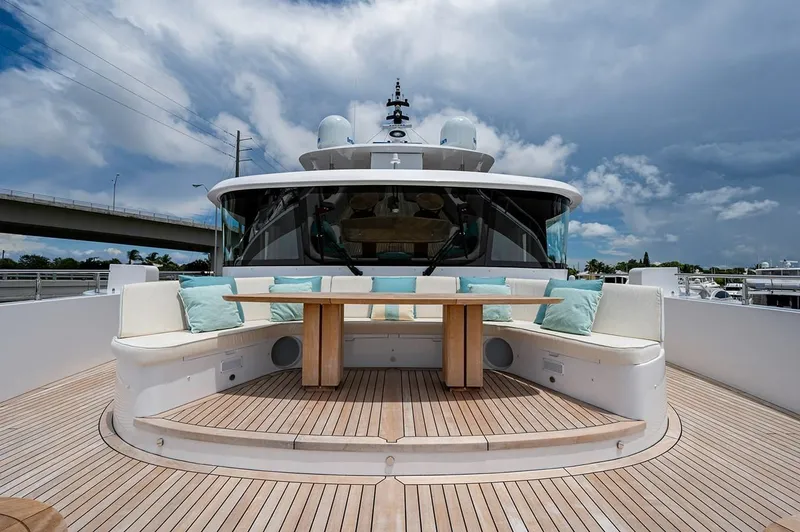 Checked Out Yacht Photos Pics Luxurious 2020 Majesty 140 yacht deck with seating and table under cloudy sky.