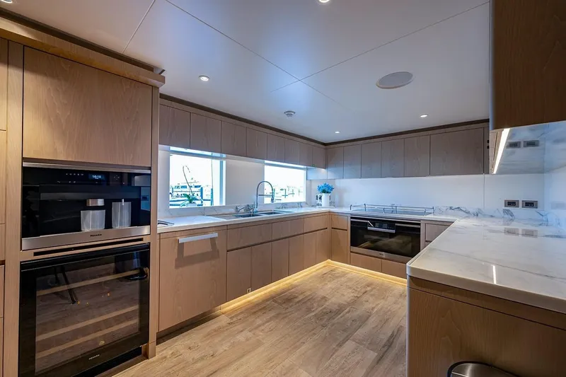 Checked Out Yacht Photos Pics Modern kitchen interior on 2020 Majesty 140 yacht, featuring sleek cabinetry and appliances.