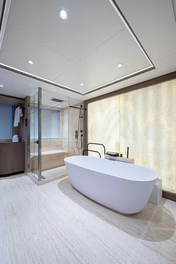 Checked Out Yacht Photos Pics Luxurious Majesty 140 yacht bathroom, 2020 model, featuring modern bathtub and glass shower.