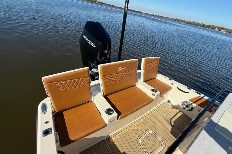  Yacht Photos Pics 2025 Scout 261 XSS boat with tan seating and Mercury engine on calm water.
