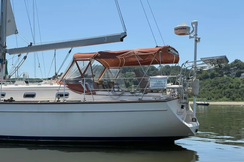 Juniper Yacht Photos Pics 2002 Island Packet 420 sailboat with tan canopy, for sale on calm water.