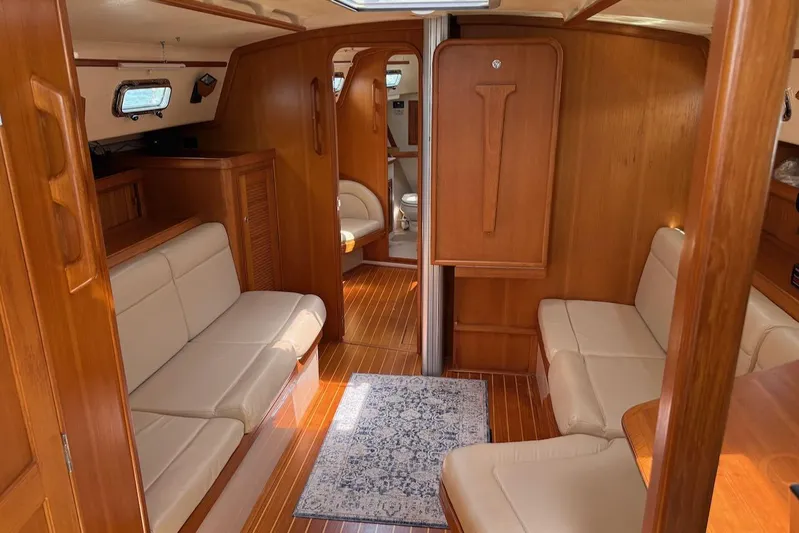 Juniper Yacht Photos Pics Interior of 2002 Island Packet 420 yacht with wooden finish and beige seating.