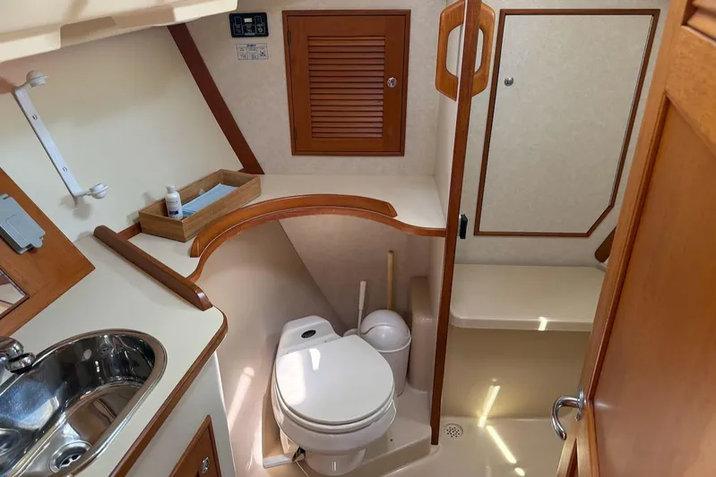 Juniper Yacht Photos Pics 2002 Island Packet 420 yacht bathroom with toilet, sink, and wooden accents.