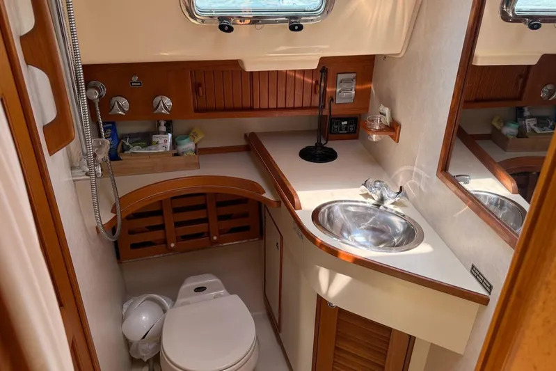 Juniper Yacht Photos Pics 2002 Island Packet 420 yacht bathroom with sink, toilet, and wooden cabinetry.