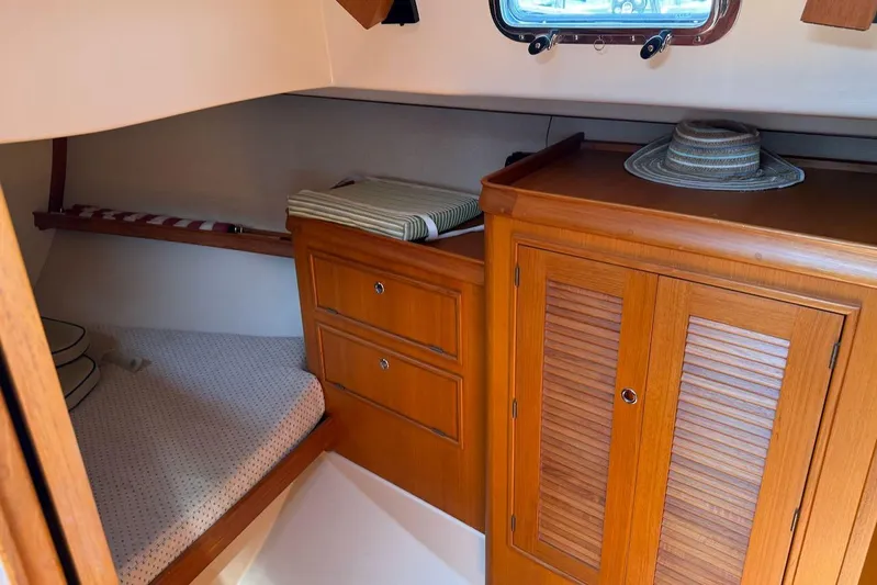 Juniper Yacht Photos Pics Cozy cabin interior of 2002 Island Packet 420 sailboat with wooden cabinetry and bedding.