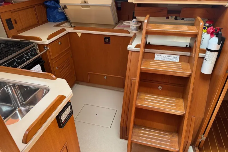 Juniper Yacht Photos Pics 2002 Island Packet 420 yacht interior with wooden cabinetry, stairs, stove, and sink.