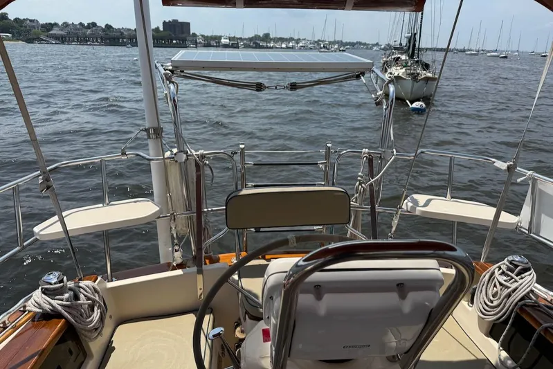 Juniper Yacht Photos Pics Cockpit view of 2002 Island Packet 420 sailboat with solar panel and marina backdrop.