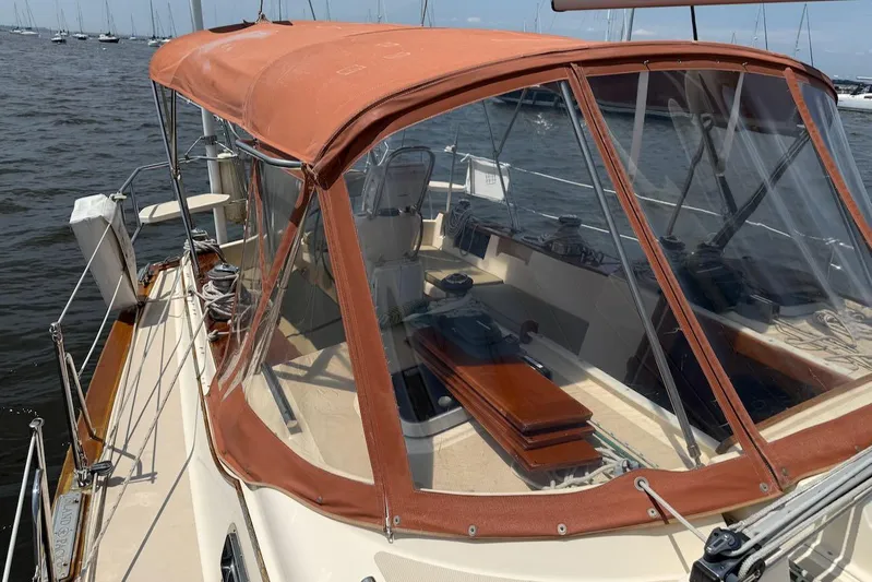 Juniper Yacht Photos Pics 2002 Island Packet 420 sailboat with tan canopy, docked in a marina.