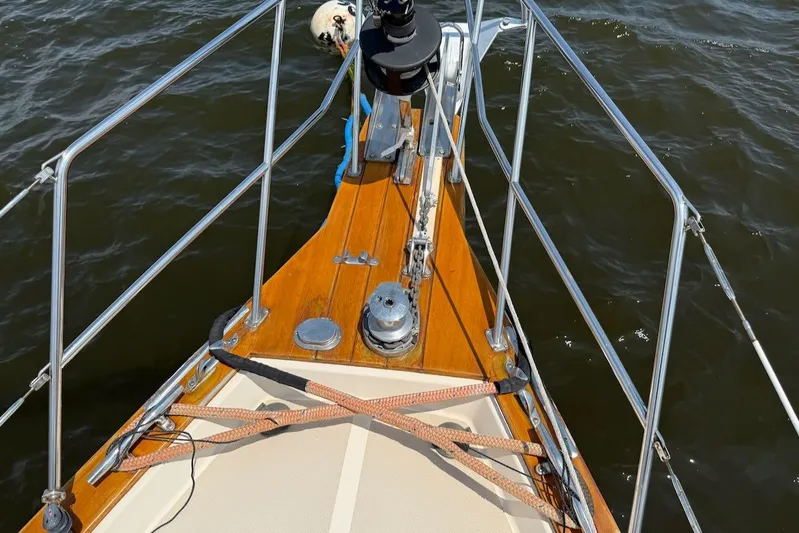 Juniper Yacht Photos Pics Bow of 2002 Island Packet 420 sailboat with wooden deck and metal railings.