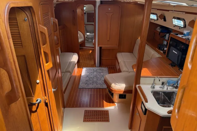 Juniper Yacht Photos Pics Interior of 2002 Island Packet 420 yacht with wood finish and cozy seating area.