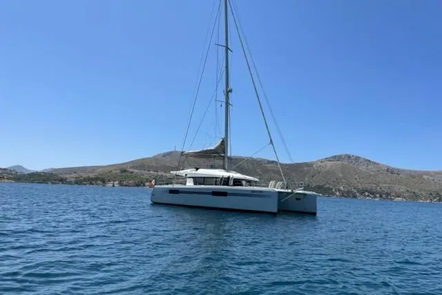 Mojito Yacht Photos Pics 2016 Lagoon 52 F catamaran sailing on calm blue waters with scenic hills in the background.