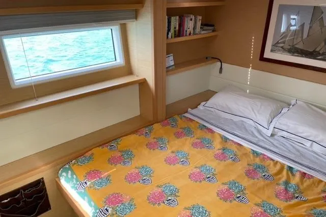 Mojito Yacht Photos Pics Cozy cabin interior of 2016 Lagoon 52 F yacht with bed, window, and bookshelf.