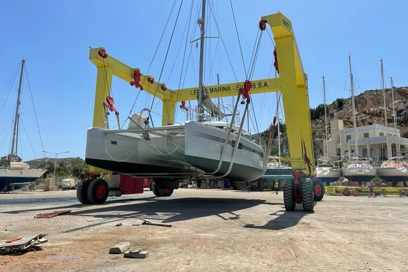 Mojito Yacht Photos Pics 2016 Lagoon 52 F catamaran lifted by yellow crane in marina.