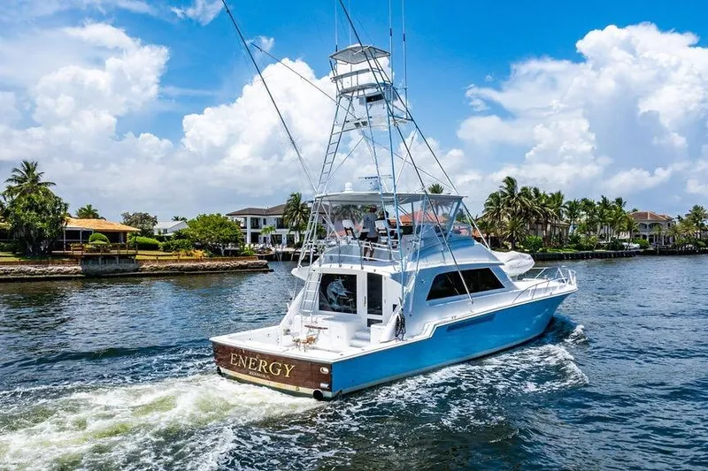 Energy Yacht Photos Pics 1998 Bertram 60 Convertible yacht cruising on a sunny day near waterfront homes.