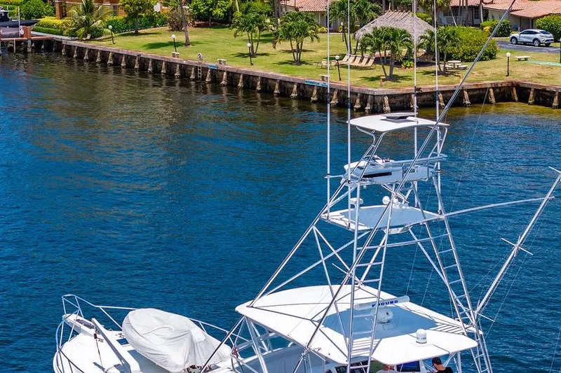 Energy Yacht Photos Pics 1998 Bertram 60 Convertible yacht docked by a scenic waterfront.
