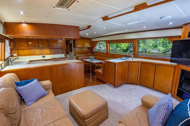 Energy Yacht Photos Pics Luxurious interior of 1998 Bertram 60 Convertible yacht with wood finishes and plush seating.
