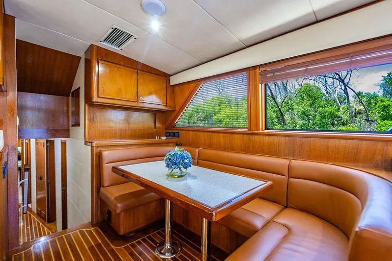 Energy Yacht Photos Pics Luxurious interior of 1998 Bertram 60 Convertible yacht with wood paneling and leather seating.