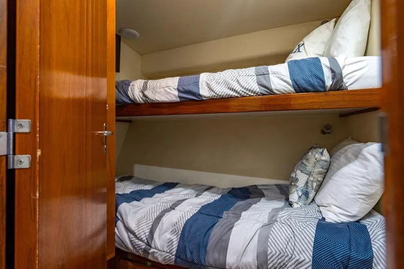 Energy Yacht Photos Pics Bunk beds in 1998 Bertram 60 Convertible yacht cabin with striped bedding.