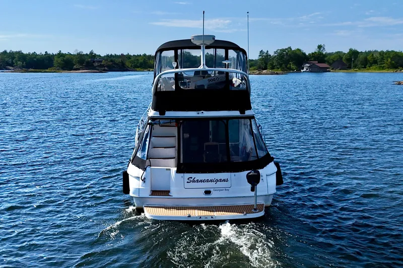 Shaneanigans Yacht Photos Pics 1998 Sea Ray 400 Sedan Bridge cruising on a serene lake with lush shoreline.