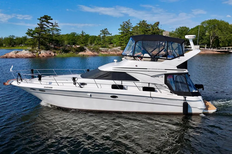Shaneanigans Yacht Photos Pics 1998 Sea Ray 400 Sedan Bridge yacht cruising on a scenic lake.