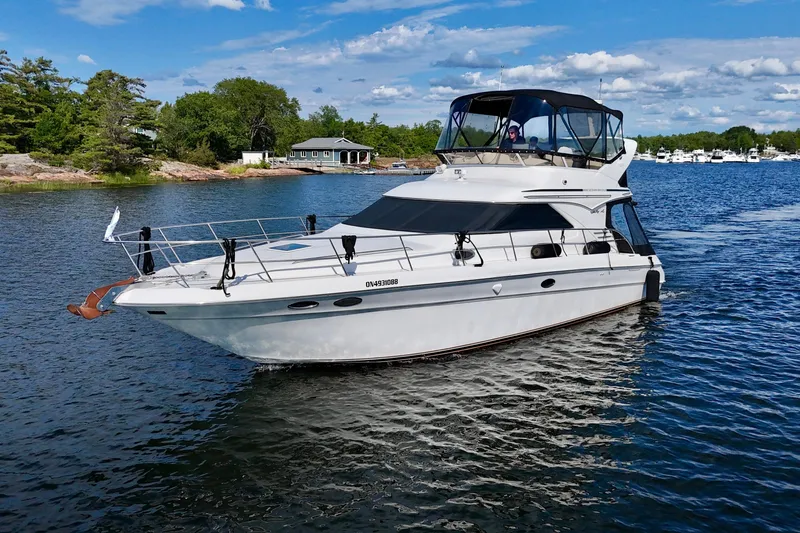 Shaneanigans Yacht Photos Pics 1998 Sea Ray 400 Sedan Bridge yacht cruising on a scenic lake.