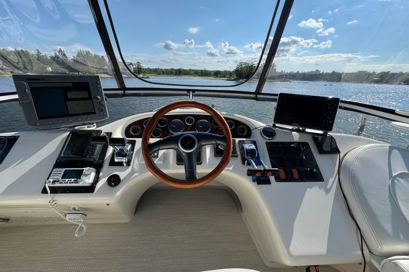 Shaneanigans Yacht Photos Pics 1998 Sea Ray 400 Sedan Bridge helm with steering wheel, controls, and navigation screens.
