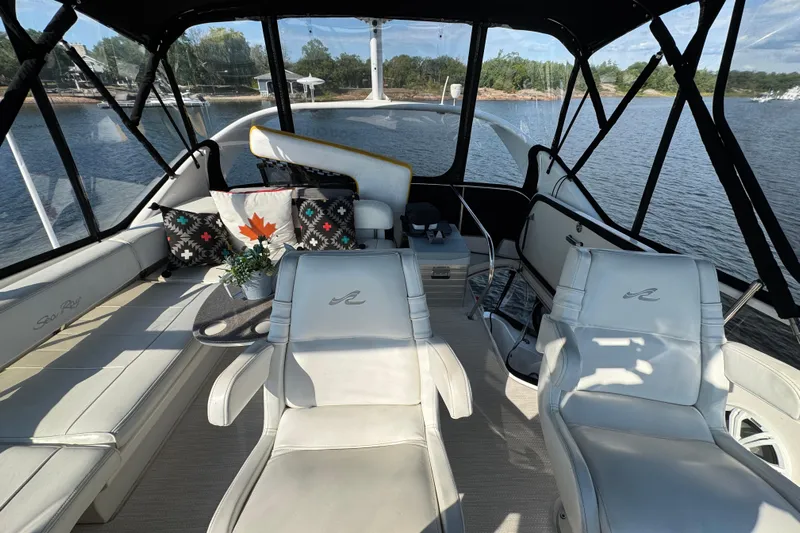 Shaneanigans Yacht Photos Pics 1998 Sea Ray 400 Sedan Bridge interior with white seating, lake view, and decorative pillows.