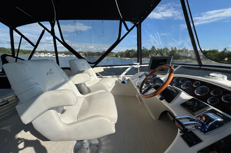 Shaneanigans Yacht Photos Pics 1998 Sea Ray 400 Sedan Bridge helm with white seats and wooden steering wheel.