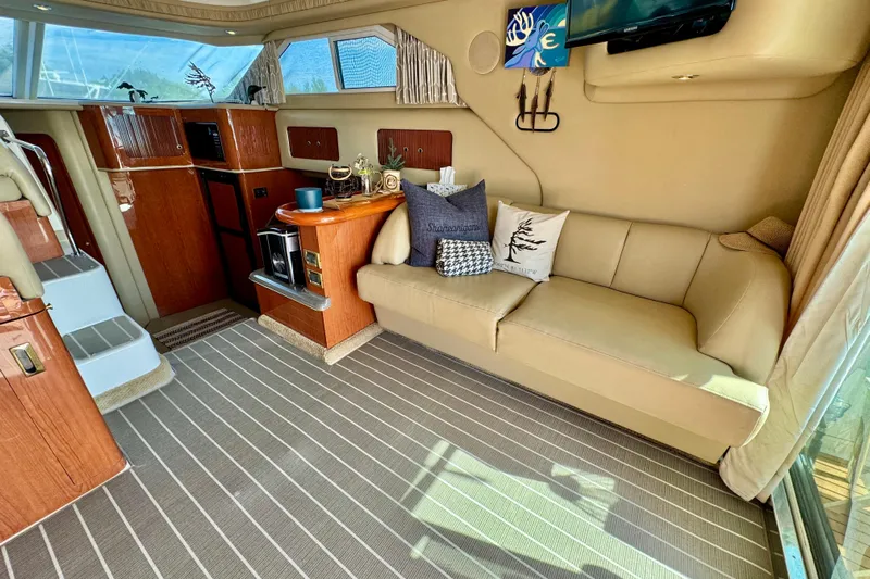 Shaneanigans Yacht Photos Pics Luxurious interior of 1998 Sea Ray 400 Sedan Bridge yacht with beige sofa and wooden cabinetry.