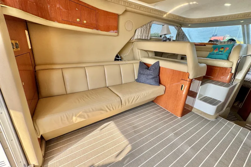 Shaneanigans Yacht Photos Pics 1998 Sea Ray 400 Sedan Bridge interior with beige leather seating and wooden accents.