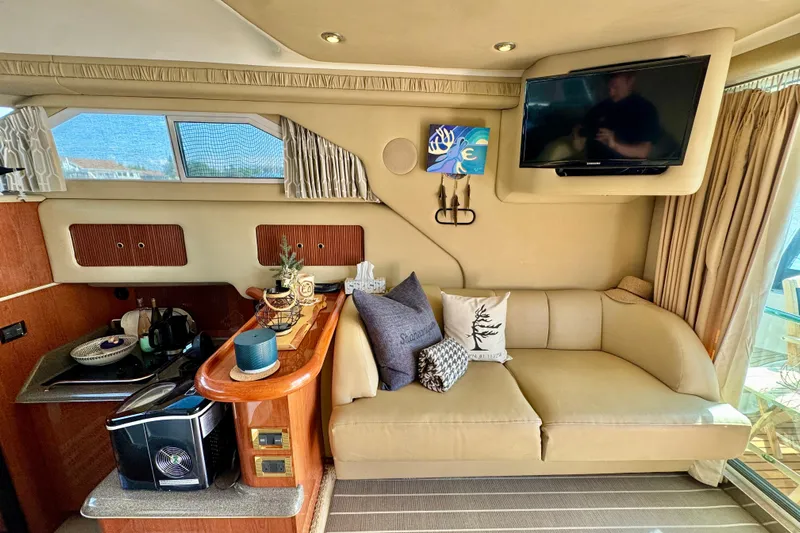 Shaneanigans Yacht Photos Pics Interior of 1998 Sea Ray 400 Sedan Bridge with sofa, TV, and kitchenette.