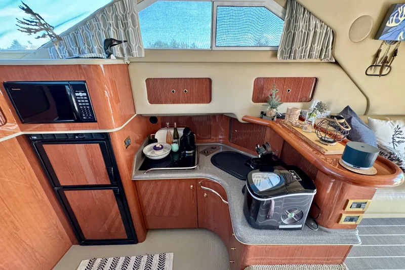 Shaneanigans Yacht Photos Pics 1998 Sea Ray 400 Sedan Bridge interior kitchen with microwave, fridge, and modern appliances.