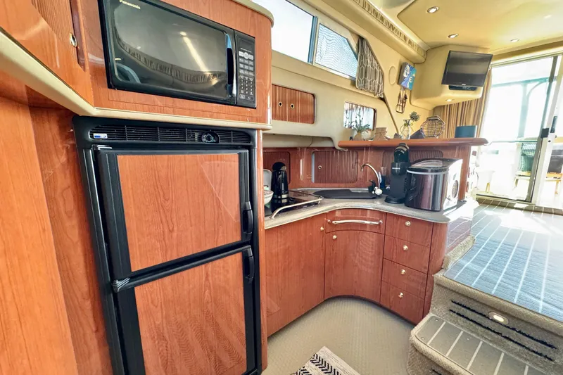 Shaneanigans Yacht Photos Pics Luxurious 1998 Sea Ray 400 Sedan Bridge yacht kitchen with modern appliances and wood cabinetry.