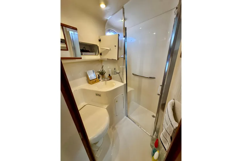 Shaneanigans Yacht Photos Pics 1998 Sea Ray 400 Sedan Bridge bathroom with shower, sink, and storage cabinets.
