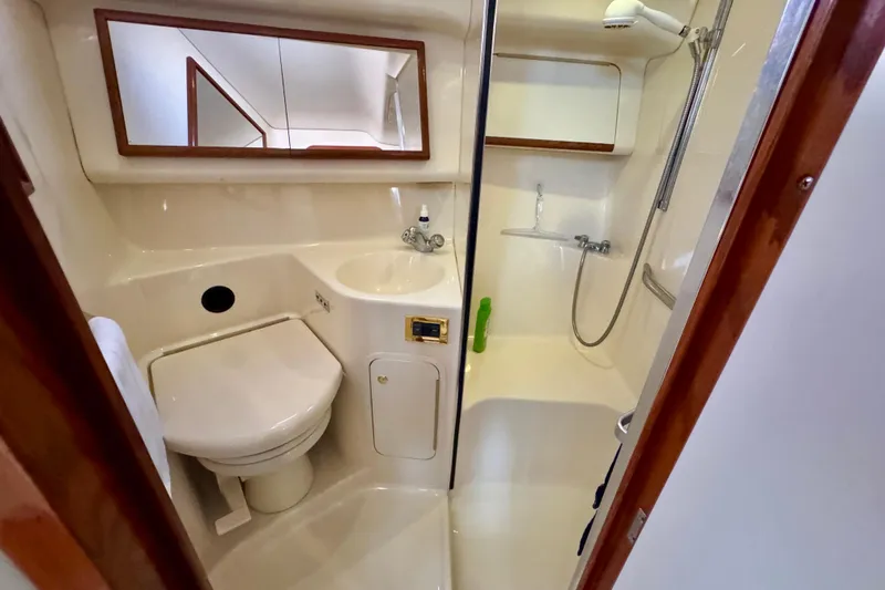 Shaneanigans Yacht Photos Pics 1998 Sea Ray 400 Sedan Bridge bathroom with shower, toilet, and sink.