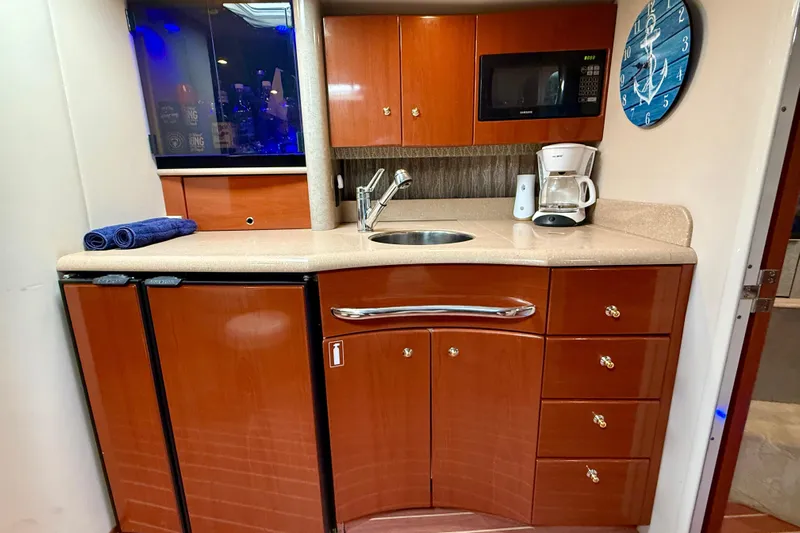 Yachtsea Yacht Photos Pics 2004 Formula 40 Performance Cruiser kitchen with wood cabinets, sink, microwave, and coffee maker.