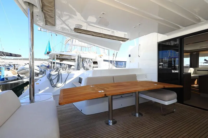  Yacht Photos Pics Lagoon 50 2021 yacht with spacious outdoor seating and wooden table in marina.