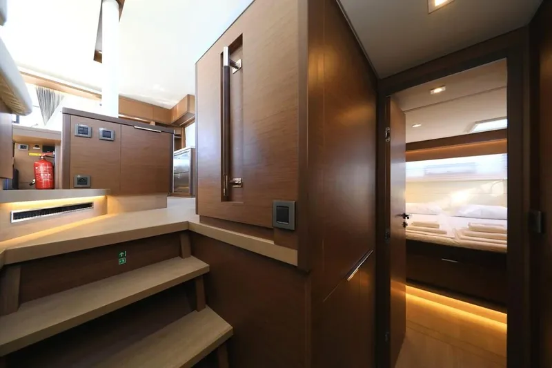  Yacht Photos Pics Interior of 2021 Lagoon 50 catamaran, featuring modern wooden cabinetry and cozy sleeping quarters.