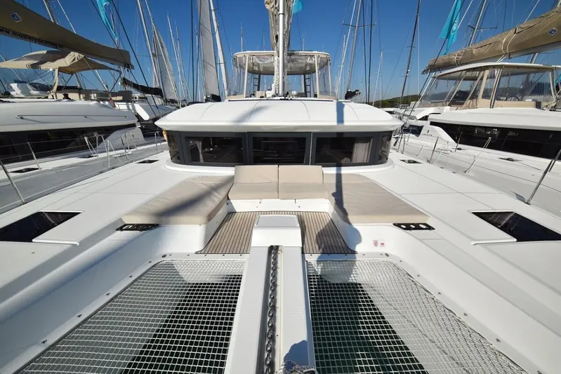 Yacht Photos Pics 2021 Lagoon 50 catamaran with spacious deck and netting, docked among other yachts.