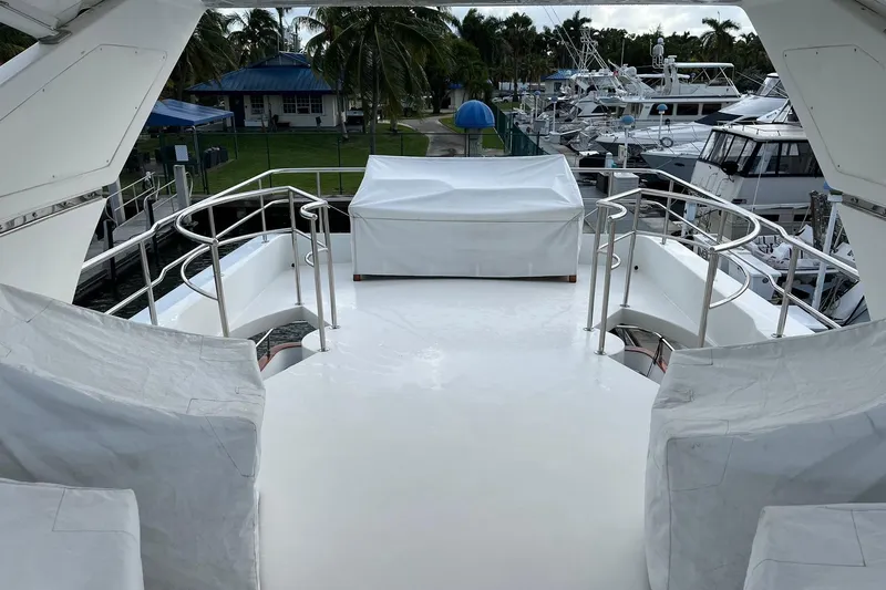 Atlantis Yacht Photos Pics Deck view of 1996 Hershine Benship 87 yacht, featuring covered seating and marina backdrop.