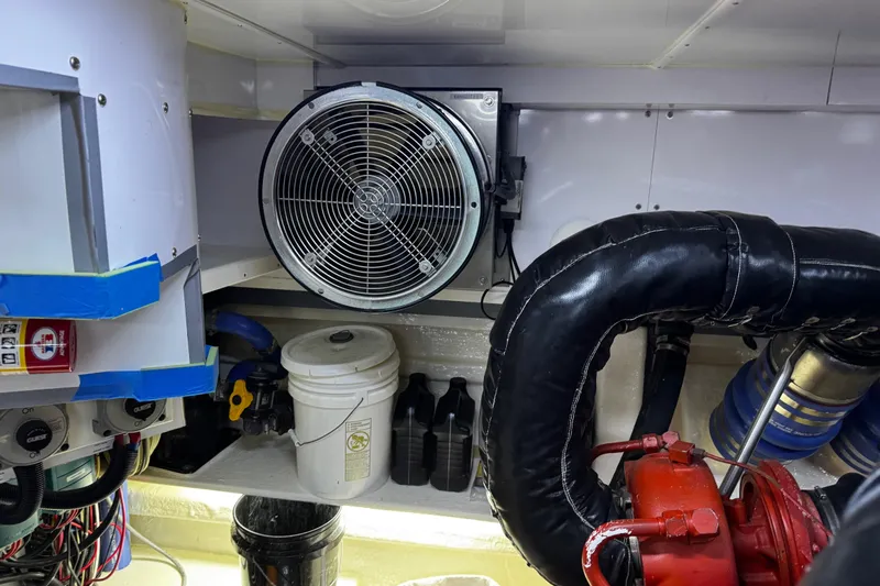 Atlantis Yacht Photos Pics Engine room of 1996 Hershine Benship 87 with fan, pipes, and equipment.
