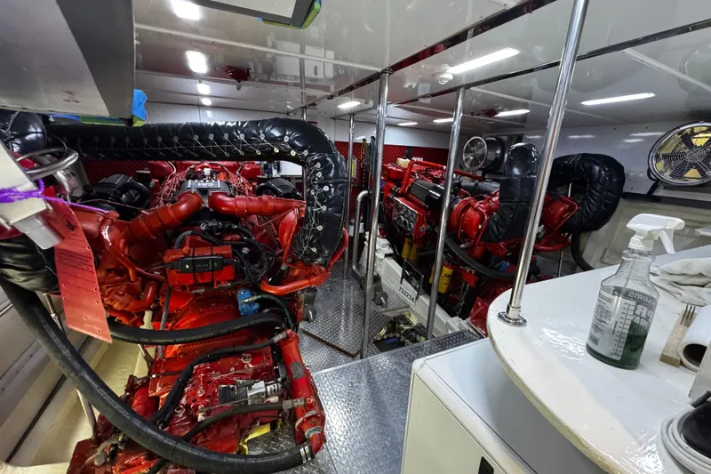 Atlantis Yacht Photos Pics Engine room of 1996 Hershine Benship 87 yacht with red machinery and equipment.