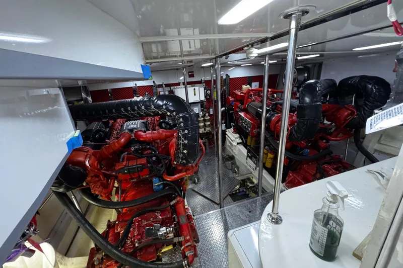 Atlantis Yacht Photos Pics Engine room of 1996 Hershine Benship 87 yacht with red machinery and metallic flooring.