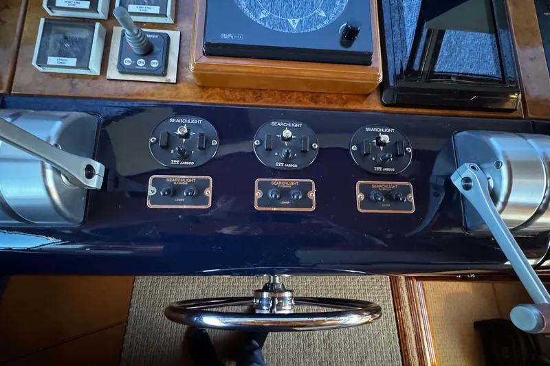 Atlantis Yacht Photos Pics Control panel of a 1996 Hershine Benship 87 yacht with searchlight switches and steering wheel.
