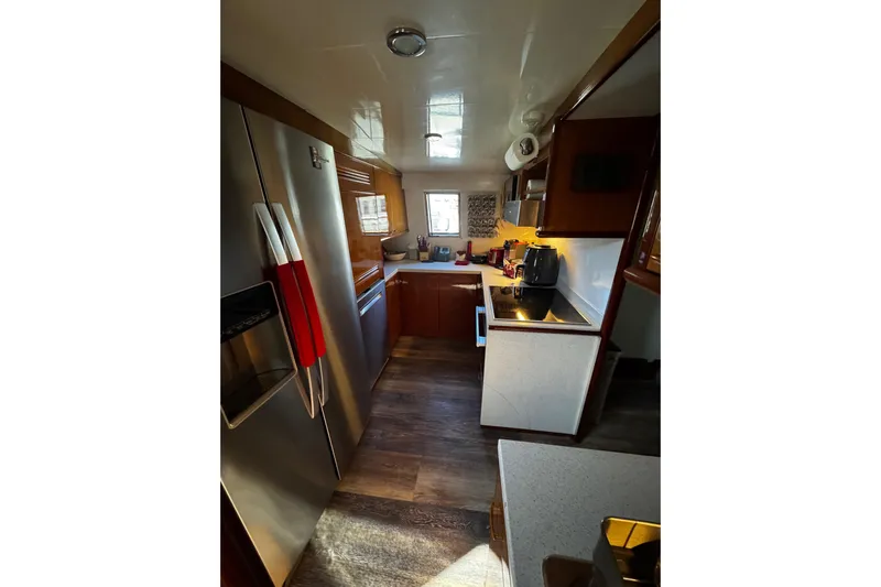 Atlantis Yacht Photos Pics Interior of 1996 Hershine Benship 87 yacht kitchen with modern appliances and wood accents.