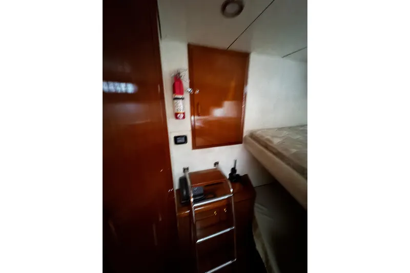 Atlantis Yacht Photos Pics Interior of 1996 Hershine Benship 87 yacht with wooden cabinetry and a bed.